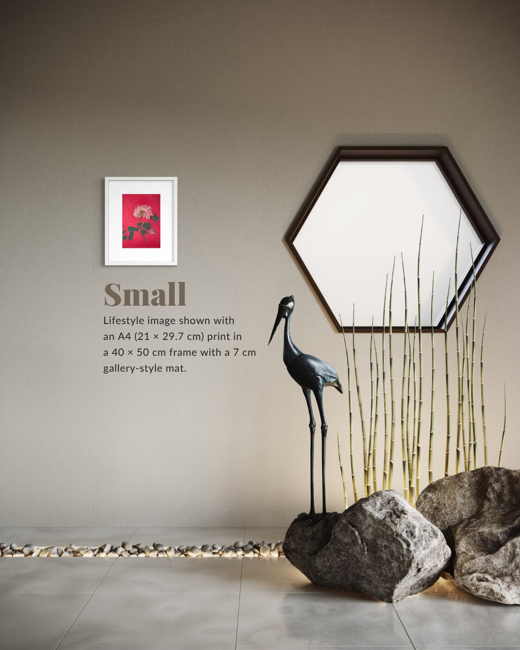 A framed wall art print shown in a styled interior scene. The product appears to be a small art print with a red and pink floral design in a white frame, mounted on a beige wall beside a hexagonal mirror, a black crane sculpture, bamboo, and rocks.