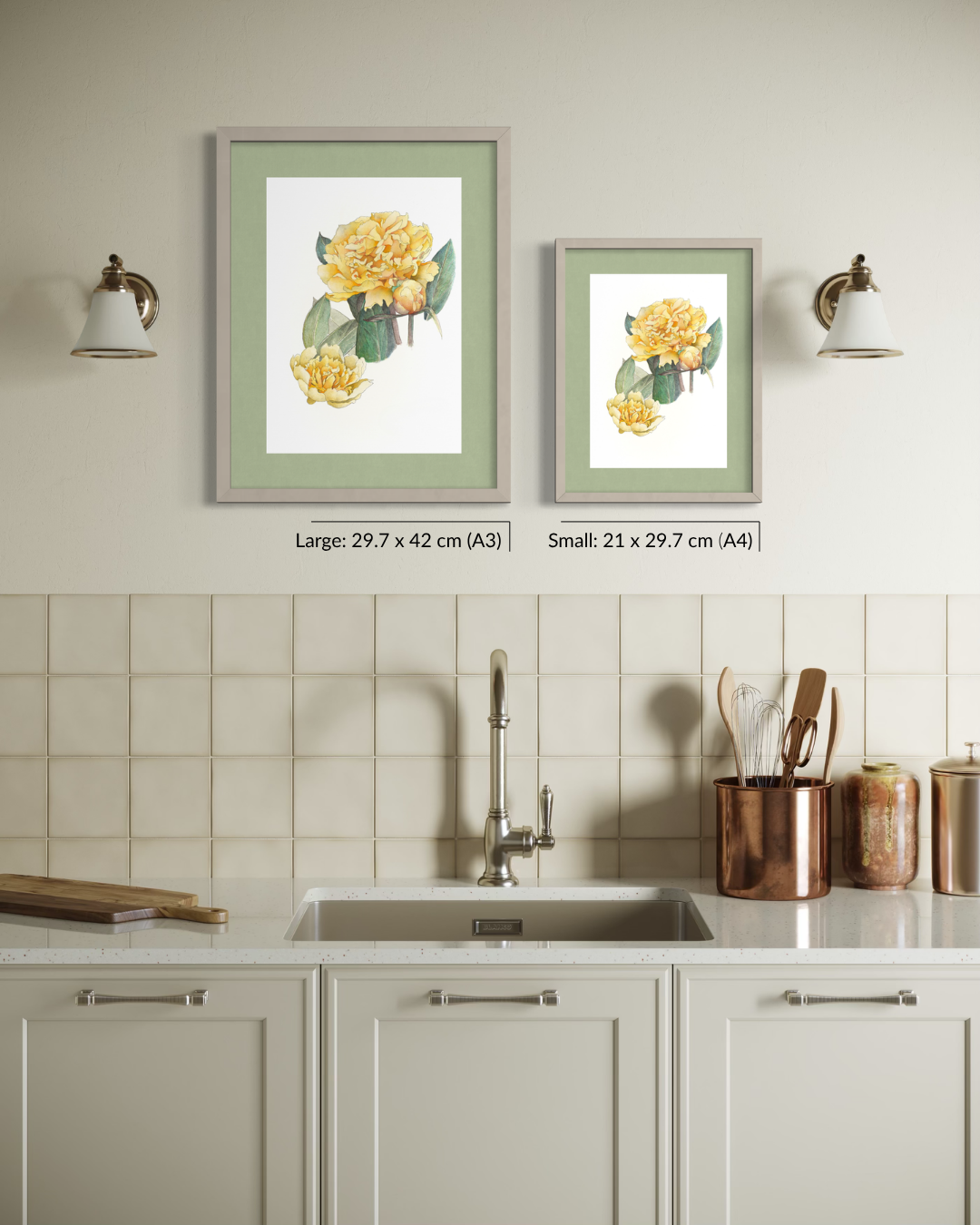 Two framed botanical art prints with yellow flowers and green leaves hang on a beige wall above a kitchen sink. The larger print is labeled 29.