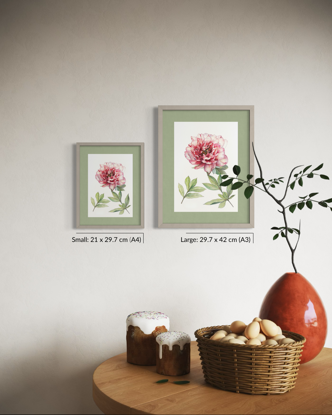Two framed floral wall art prints are displayed on a beige wall above a wooden table with a basket, jars, and a vase. The larger print is labeled 29.