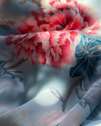 A close-up of a lightweight fabric with a watercolor-style floral print, featuring large pink and red blossoms and blue leaves on a pale blue background.