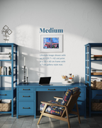 A styled home office interior with a blue desk and shelving, a patterned chair, and a framed wall print. Text on the wall reads 'Medium' and describes the print size and lifestyle image context.